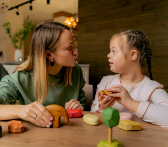 A support worker engaging with a young girl during a personal care activity, symbolising NDIS personal support and empowerment.