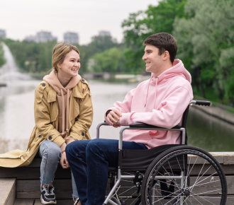 A support worker assisting a man from a van into a wheelchair, symbolising community participation and social activity support under the NDIS.